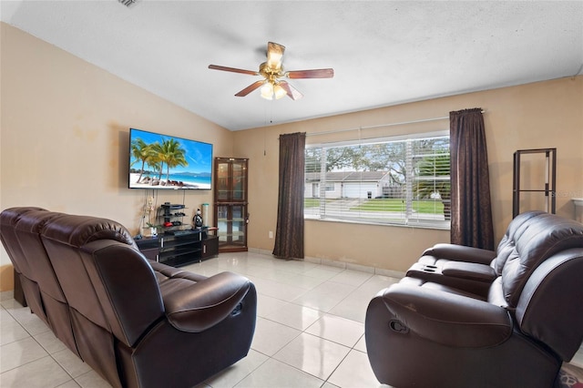 living area featuring light tile patterned floors, lofted ceiling, and a ceiling fan