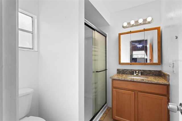 full bathroom with toilet, a shower stall, and vanity