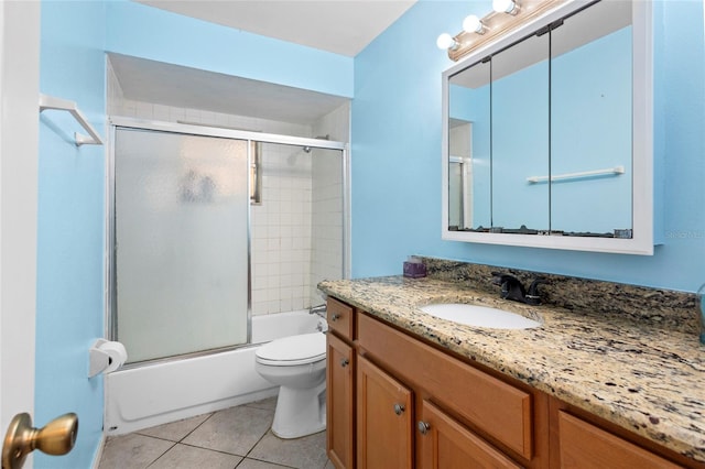 full bath with bath / shower combo with glass door, vanity, toilet, and tile patterned floors