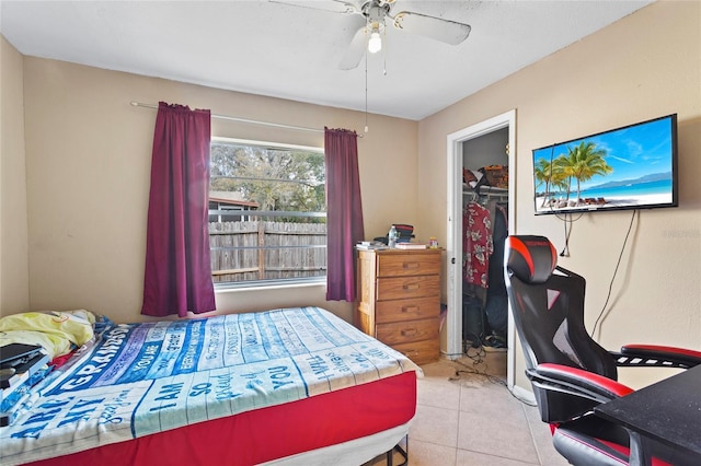 tiled bedroom featuring a walk in closet and a closet