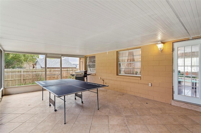 game room featuring tile patterned flooring and concrete block wall