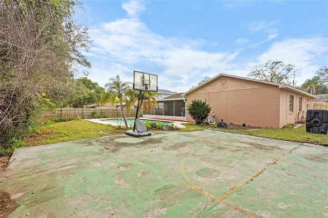 view of sport court with a fenced in pool, a fenced backyard, and a lawn