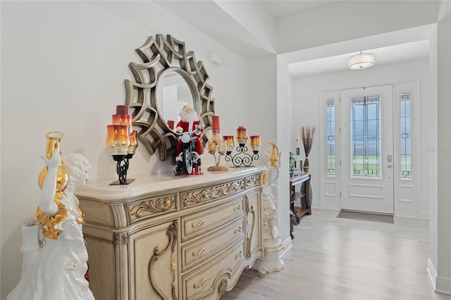 foyer entrance with light wood-style floors and baseboards