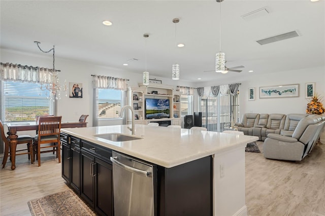 kitchen with light countertops, open floor plan, a sink, light wood-type flooring, and dishwasher