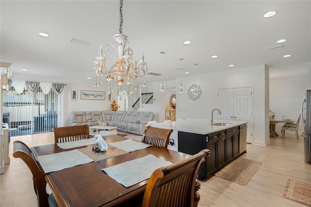 dining room featuring light wood finished floors, a notable chandelier, and recessed lighting