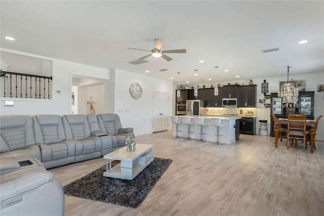 living room featuring ceiling fan, recessed lighting, visible vents, baseboards, and light wood finished floors