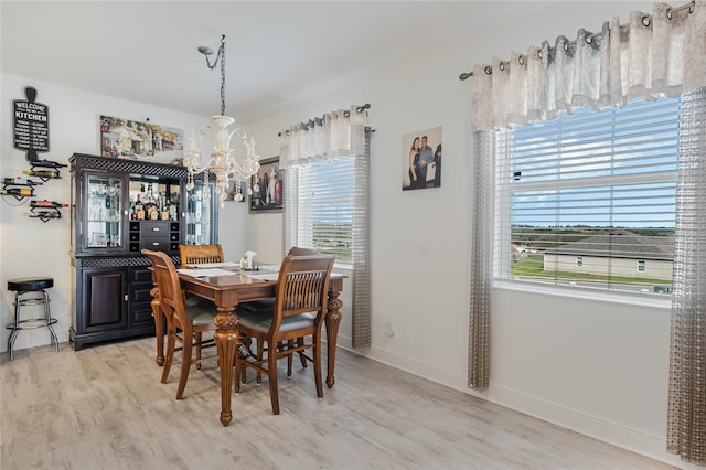 dining area with light wood finished floors, baseboards, a chandelier, and a wealth of natural light