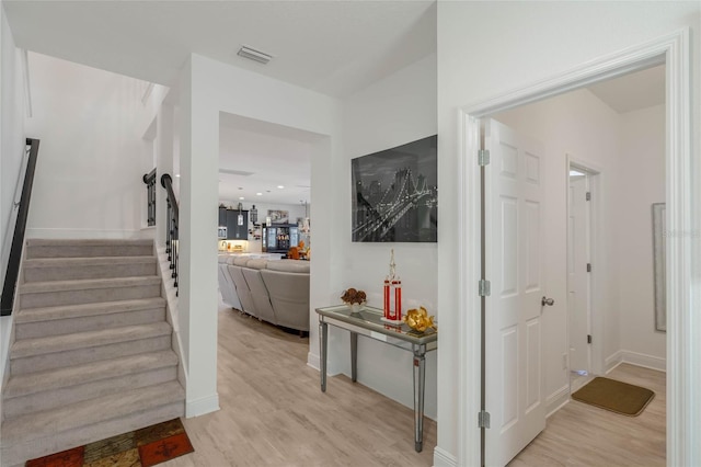 interior space with baseboards, visible vents, stairway, and light wood finished floors