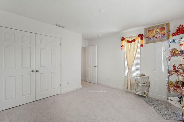 unfurnished bedroom with carpet floors, visible vents, and baseboards