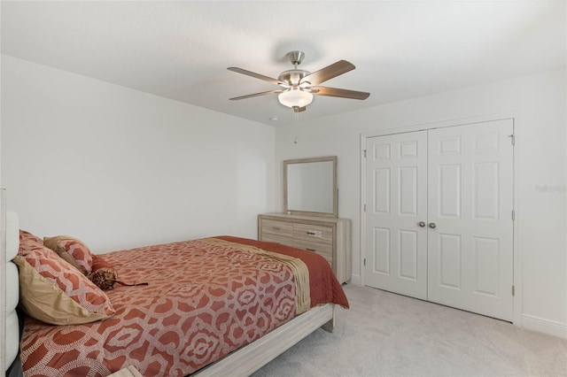 bedroom featuring a closet, light carpet, ceiling fan, and baseboards