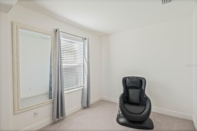 living area with a textured ceiling, carpet flooring, visible vents, and baseboards