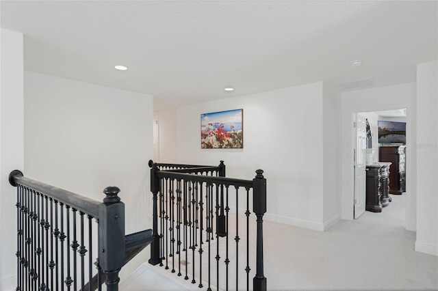 hall with recessed lighting, carpet, baseboards, and an upstairs landing