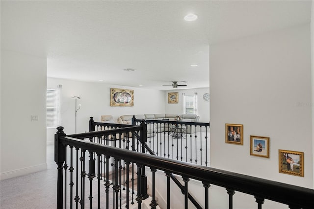 hall with carpet, recessed lighting, baseboards, and an upstairs landing