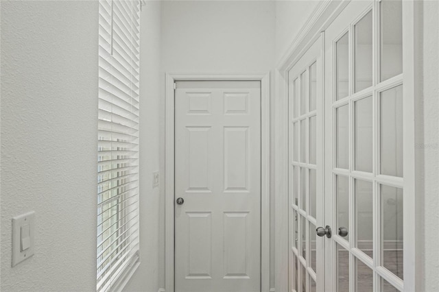 doorway to outside featuring french doors and a textured wall