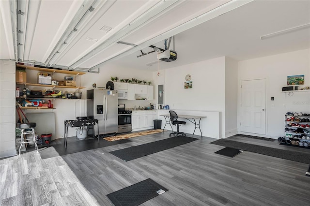 garage featuring stainless steel refrigerator with ice dispenser, electric panel, and a garage door opener