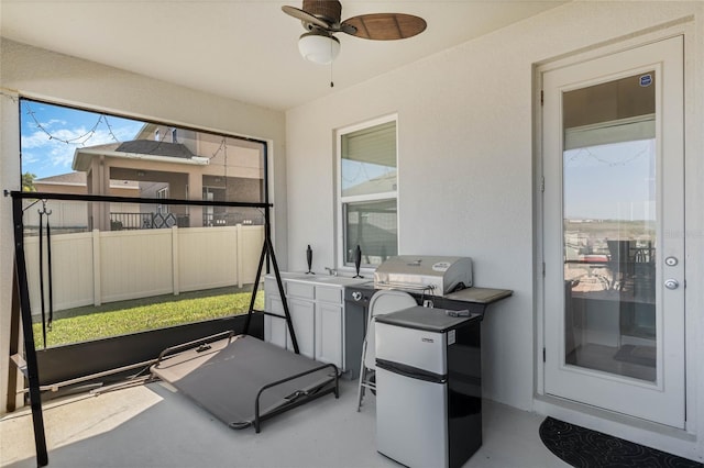 sunroom featuring ceiling fan and a sink