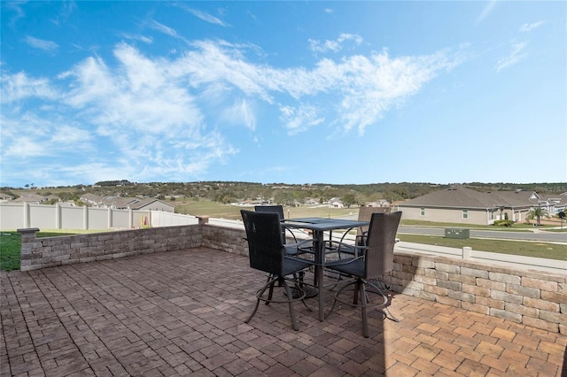 view of patio / terrace featuring a residential view, fence, and outdoor dining area