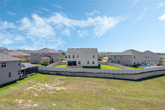 view of yard with glass enclosure, a residential view, and fence