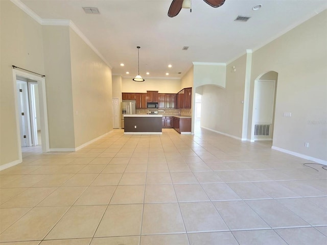 unfurnished living room featuring ornamental molding, arched walkways, visible vents, and light tile patterned flooring