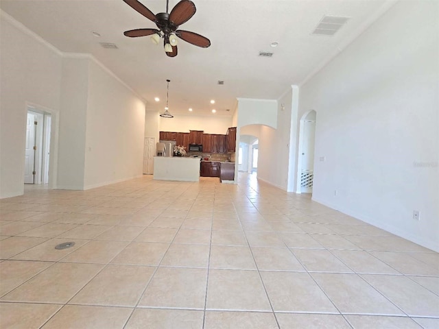 13413 Zori Ln, Windermere, FL 34786 - unfurnished living room with a ceiling fan, ornamental molding, arched walkways, light tile patterned floors, and a towering ceiling