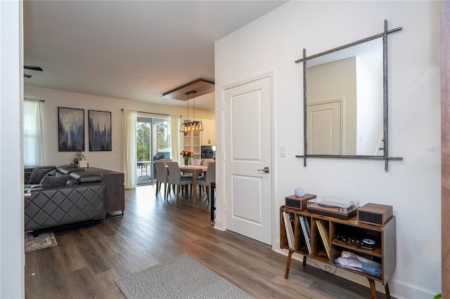 corridor featuring a chandelier and wood finished floors