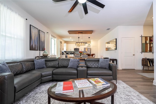 living area featuring baseboards, ceiling fan, visible vents, and dark wood-style flooring