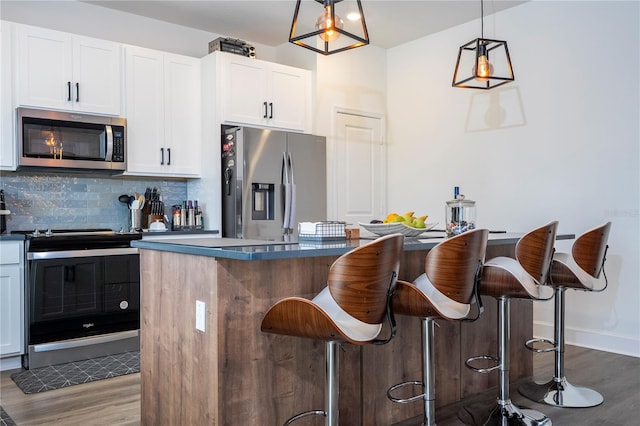 kitchen featuring stainless steel appliances, a breakfast bar, dark wood-style flooring, and decorative backsplash