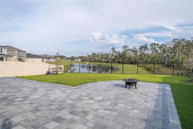 view of community with a water view, a fenced backyard, a lawn, and a patio