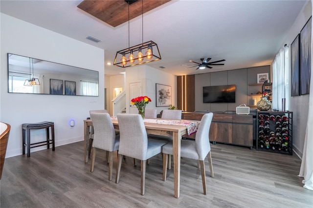 dining space with a ceiling fan, light wood-type flooring, visible vents, and baseboards