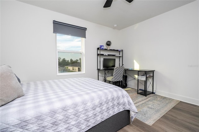 bedroom featuring wood finished floors, a ceiling fan, and baseboards