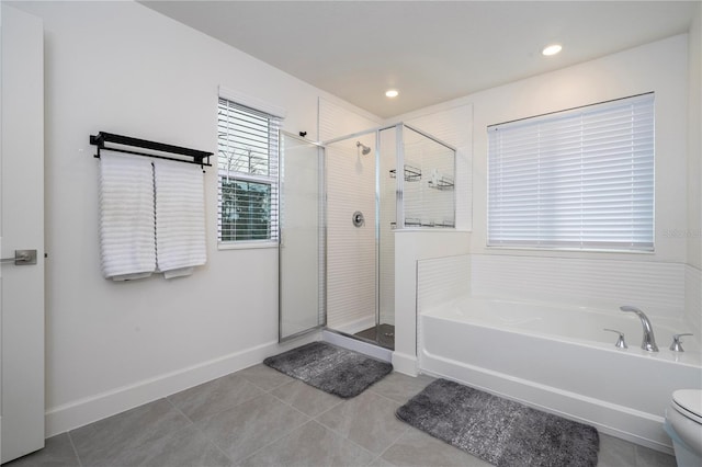 bathroom featuring a garden tub, a shower stall, and tile patterned floors