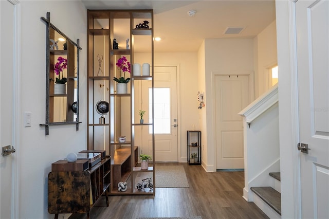 entryway featuring visible vents, stairway, and wood finished floors