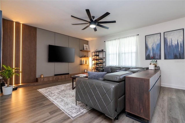 living room featuring light wood-type flooring and a ceiling fan