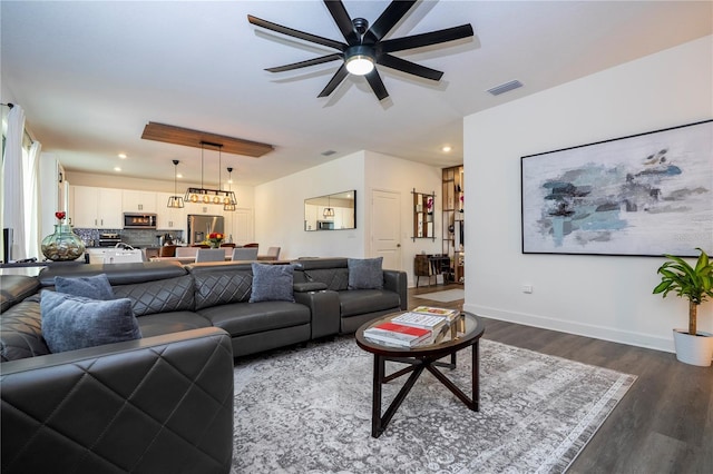 living area with visible vents, baseboards, wood finished floors, and recessed lighting