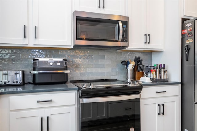 kitchen with appliances with stainless steel finishes, dark countertops, and white cabinets