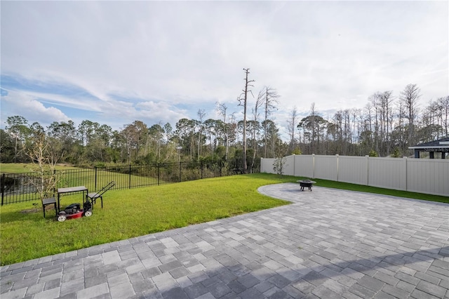 view of property's community featuring a fenced backyard, a lawn, and a patio