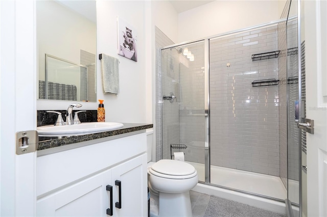 full bath featuring toilet, a stall shower, and vanity