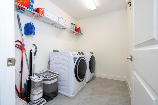 laundry room with laundry area, light tile patterned flooring, independent washer and dryer, and baseboards