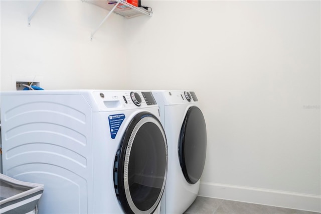 laundry area with laundry area, light tile patterned flooring, baseboards, and independent washer and dryer