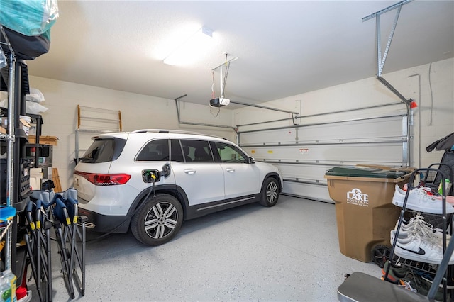 garage featuring concrete block wall and a garage door opener