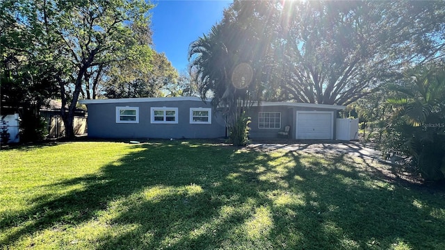 view of front of house featuring a garage, a front yard, fence, and stucco siding