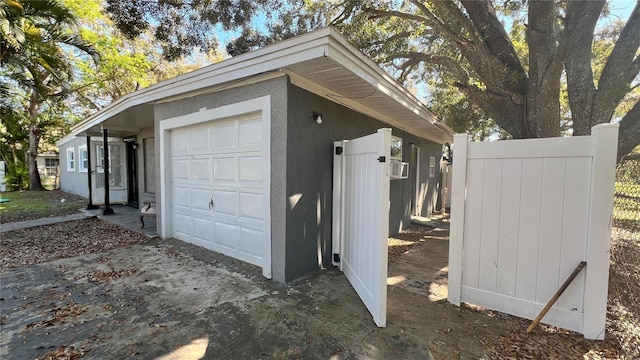 garage featuring fence and driveway