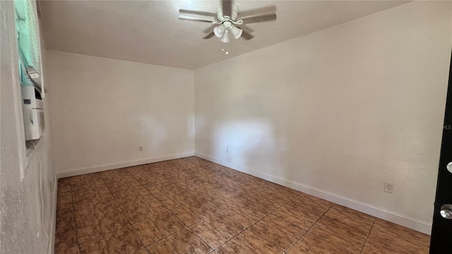 spare room with ceiling fan and baseboards