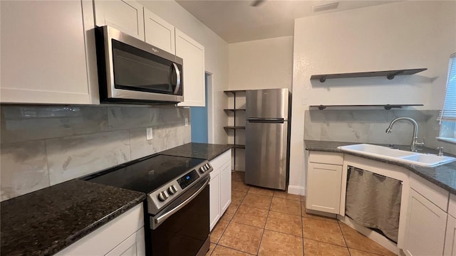 kitchen with open shelves, appliances with stainless steel finishes, a sink, and white cabinets