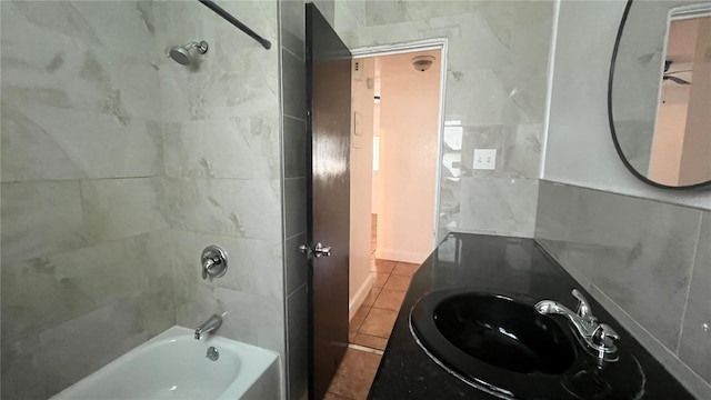 bathroom featuring tile patterned flooring, shower / bath combination, tile walls, and vanity