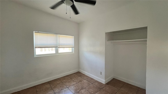 unfurnished bedroom featuring a closet, tile patterned floors, a ceiling fan, and baseboards