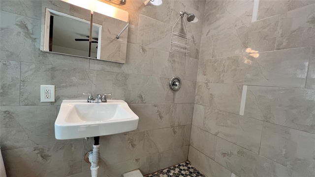 full bathroom with a tile shower and a sink