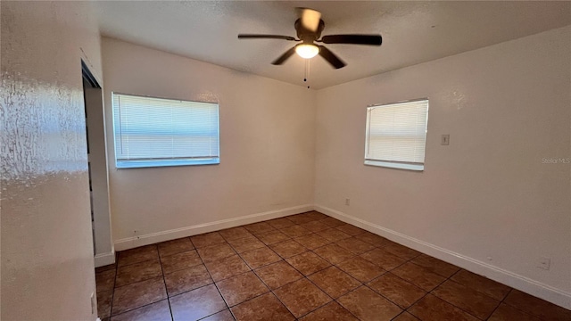 empty room featuring a ceiling fan, tile patterned flooring, and baseboards