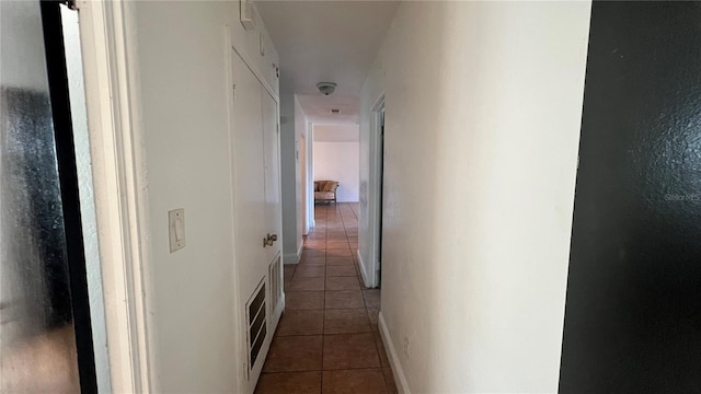 hall featuring baseboards and tile patterned floors