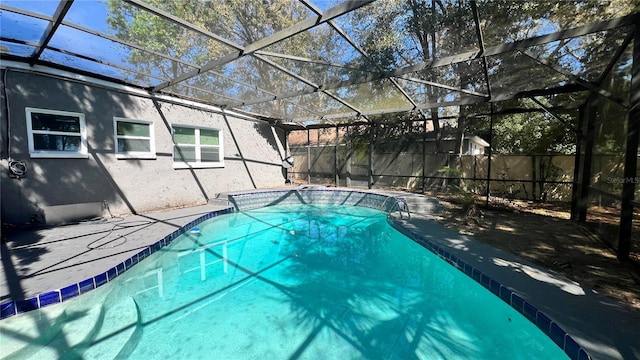 view of swimming pool with glass enclosure, a patio area, and a fenced in pool